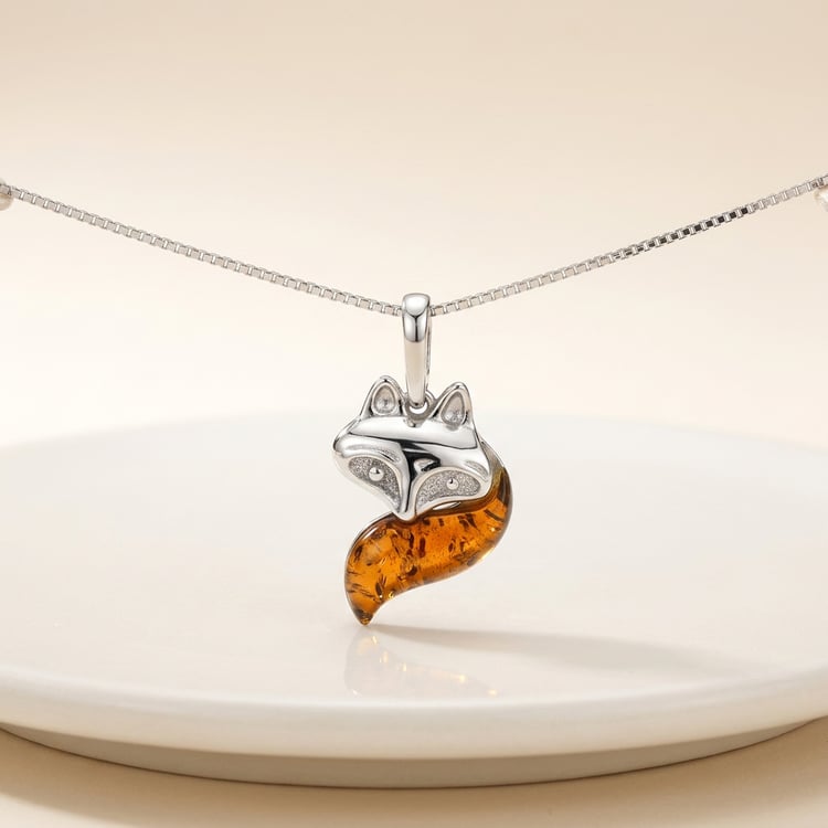 Create a high-end studio product photograph of a delicate necklace with a pendant . The necklace should be gently stretched horizontally, with the pendant hanging naturally in the center. Place the jewelry above a smooth, off-white ceramic surface with a subtle curved edge visible in the foreground. Lighting: soft diffused studio lighting from above and slightly from the side, creating a gentle shadow and a faint reflection of the pendant on the surface. Background: warm light beige to soft cream gradient, very clean and minimal. Materials must look realistic: – polished gold with soft highlights – gemstones or diamonds with subtle sparkle (not overexposed) Focus: ultra sharp on the pendant, slight depth of field falloff on the chain edges. Composition: centered, balanced, luxury e-commerce style. No distractions, no props beyond the ceramic base. Ultra realistic, high resolution, soft shadows, clean reflections, no noise, no distortion.																									 170495