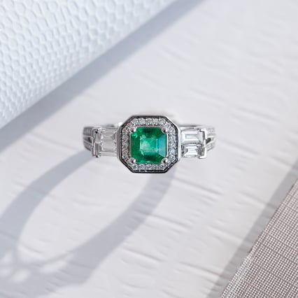 Zlatý prsten se smaragdem obklopeným diamanty Carli